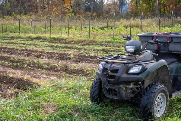 Véhicule hors route près d'un potager avec des arbres d'automne arrière-plan — Photo