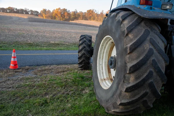 Closeup of blue tractor tire with agricultural field background — Stock Photo, Image