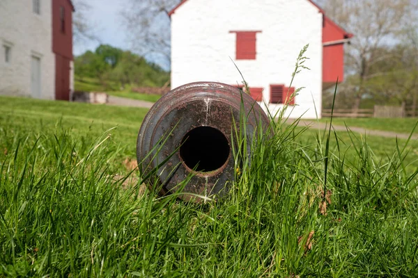 View down the barrel of a colonial cannon in the grass at iron forge — Fotografia de Stock