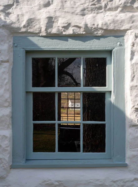 Sömürgeci Amerikan taştan kulübe penceresinden kırsal arazinin görüntüsü — Stok fotoğraf