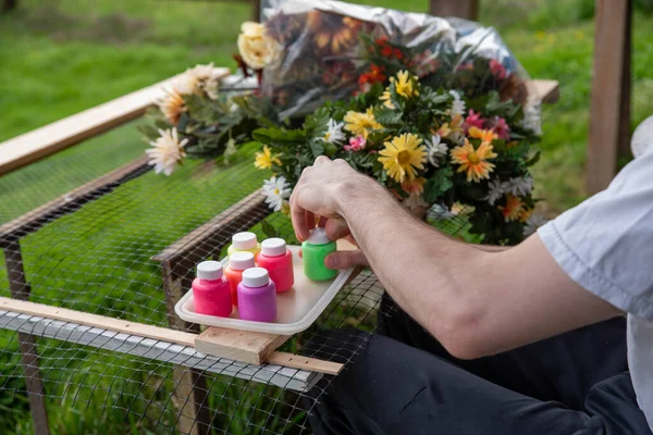 Closeup of an artists hands painting silk flowers outdoors — Fotografia de Stock