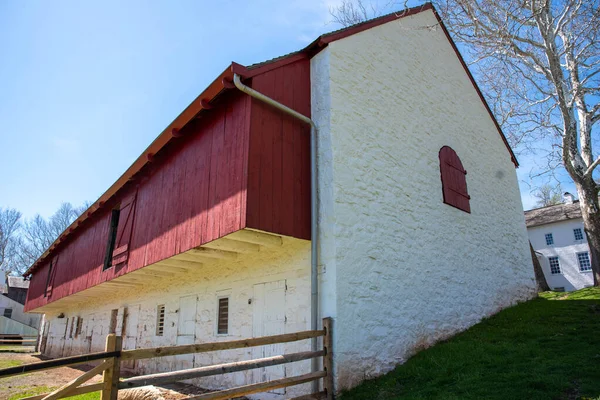 Colonial American whitewashed stone barn with red wood trim — Stock fotografie