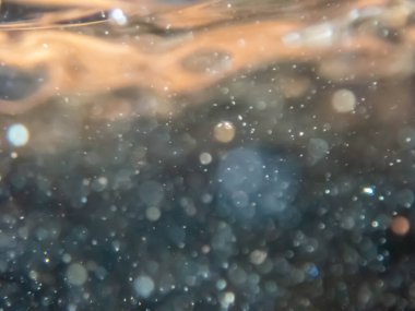 Doğal güneş ışığında parlayan renk katmanları ve damlacıklar ve baloncuklar ile çözünmüş soyut akış arkaplanı, renkli doğa nehri arka plan çekimi su altında.