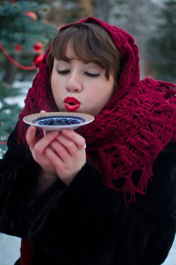 Bir çay tabağından çay içen kadın