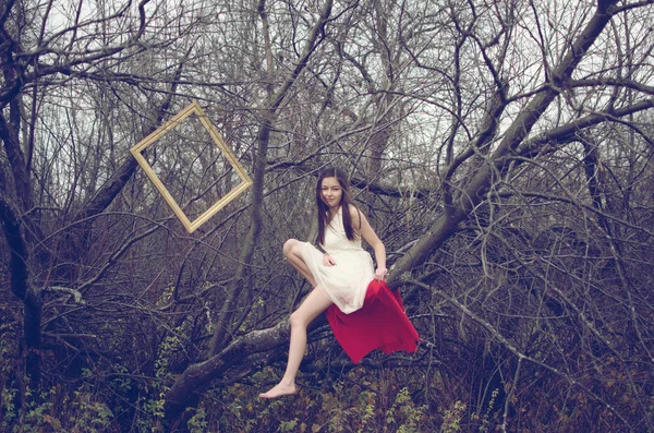 Girl sitting on the tree — Stock Photo, Image