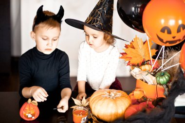 Cadılar Bayramı için cadı ve kötü kostümlü komik kız ve oğlan.