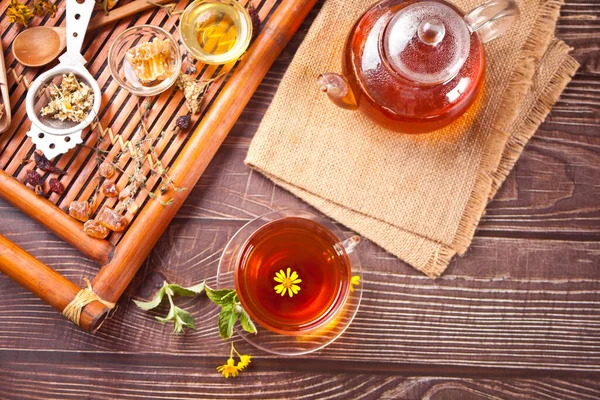 Kupa gyógynövény tea teáskanna és fából készült tálca különböző száraz gyógynövények. Felülnézet — Stock Fotó