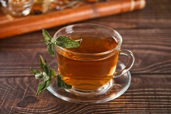 Tazza di tisana alla menta con erbe secche sul vassoio. — Foto Stock