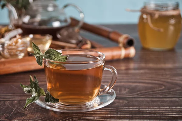 Kupa menta tea száraz gyógynövényekkel a tálcán. — Stock Fotó