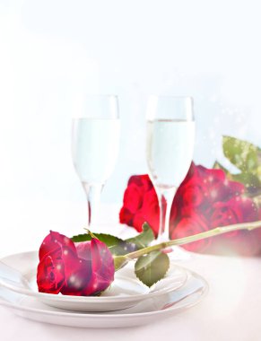 Güllü, tabaklı ve gözlüklü iki kişilik romantik restoran masası..