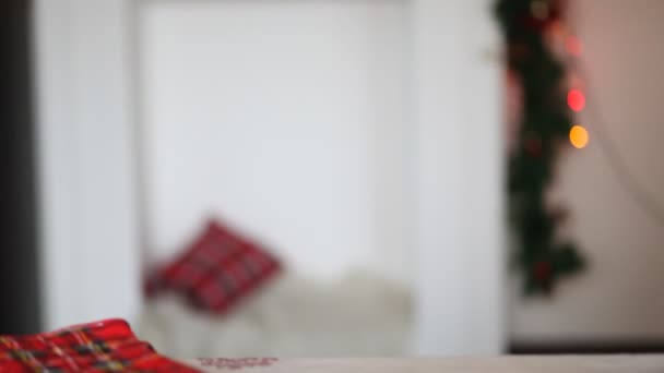 Dziecko chłopiec w czerwonej dzianiny sweter i Santa czapka umieścić na stole świąteczne pudełko i trzyma palec na ustach, aby mieć ciszę. — Wideo stockowe