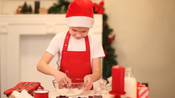 Chłopiec piecze świąteczne ciasteczka w domu. Dziecko miesza składniki w przezroczystej misce — Wideo stockowe
