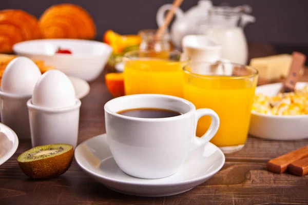 En kopp kaffe, juice, ägg, frukt, rostat bröd. Frukostkoncept. — Stockfoto