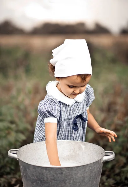 Menina bebê bonecas de lavagem em uma bacia de lata. Estilo retrô. — Fotografia de Stock