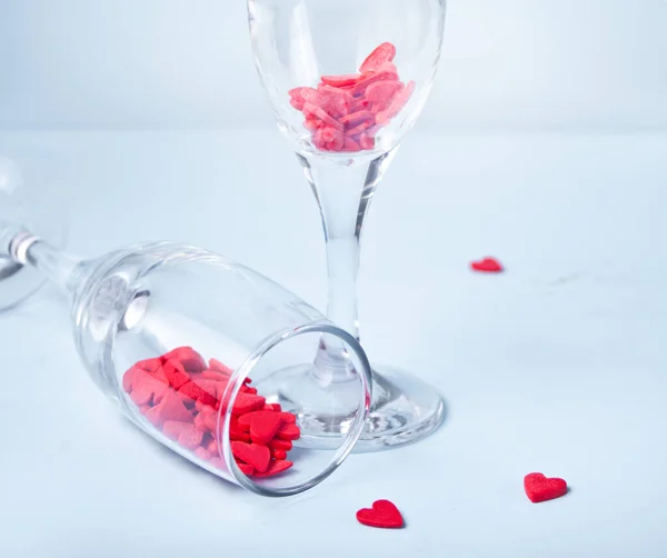 Deux verres à champagne avec bonbons en forme de coeur rouge. Concept Saint-Valentin. — Photo