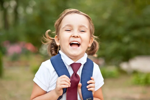 Piccola studentessa carina in uniforme con zaino borsa scuola — Foto Stock