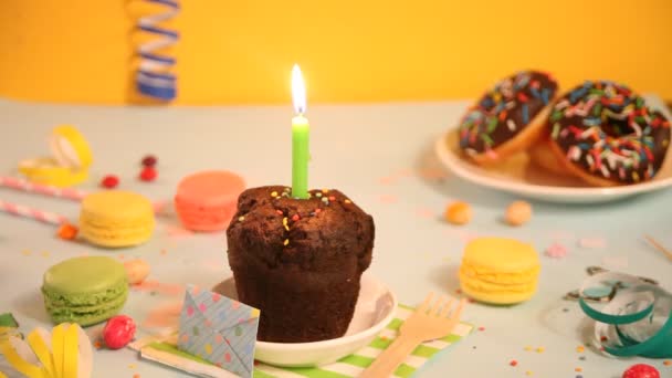 Alguien sopla la vela de cumpleaños en la deliciosa magdalena de chocolate. Concepto del partido. — Vídeo de stock