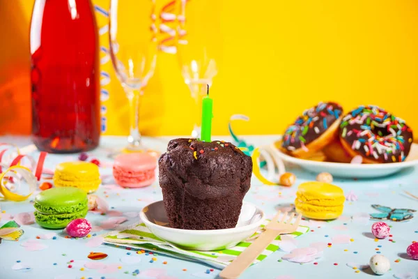 Delicioso bolo de bolinho de chocolate com vela de aniversário e outros doces e doces no fundo. Conceito de partido — Fotografia de Stock