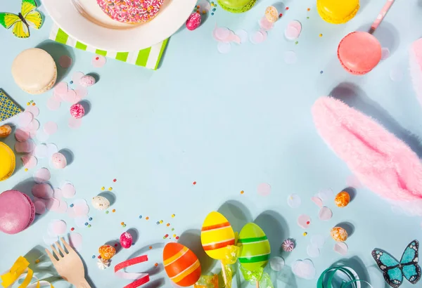 Keret beállítva húsvéti party ünneplés finom fánk rózsaszín cukormáz, macaroons, cukorka, nyuszifül a kék háttérben. Első látásra. Fénymásolási hely. — Stock Fotó