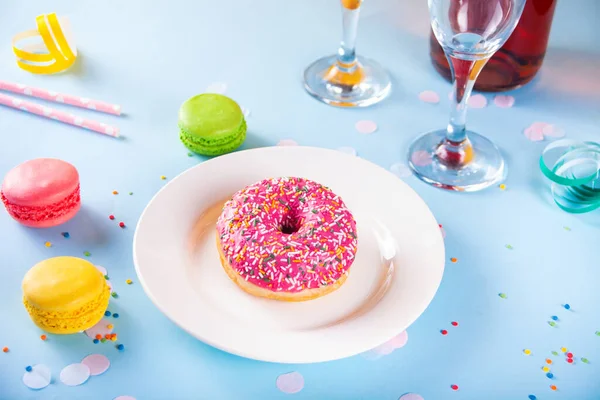 Delicioso donut com cobertura rosa e garrafa de vinho, copos e macaroons no fundo. Conceito de aniversário. — Fotografia de Stock