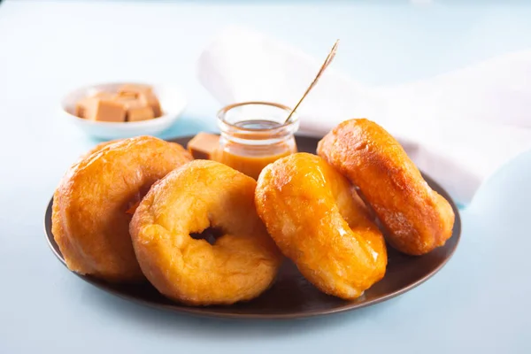 Rosquillas deliciosas caseras con salsa de jarabe de caramelo en el plato —  Fotos de Stock