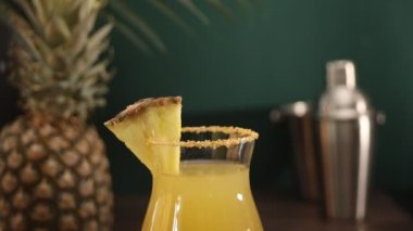 Yaz ferahlatıcı tropikal içecek suyu ya da ananas suyu ve tekila ile kokteyl. Kadın eli bardağa kağıt kamış koydu..