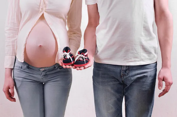 Young pregnant couple in jeans expecting a baby boy holding litt — Stock Photo, Image