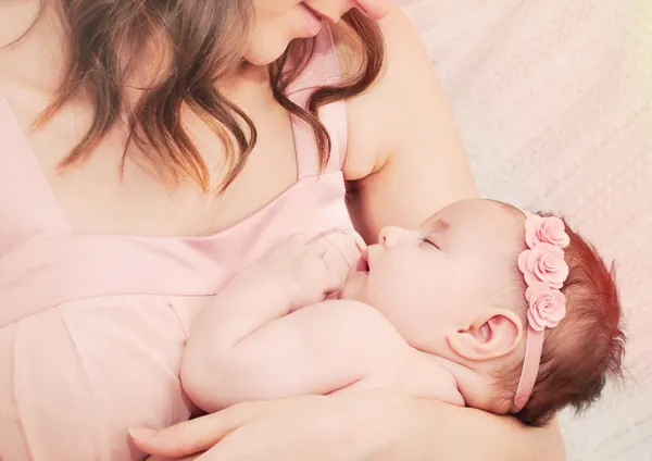 Şefkatli anne sevgi ile tutarak onun küçük sevimli uyuyan bebek gi — Stok fotoğraf