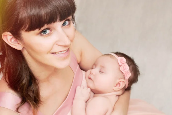 Bela mãe feliz segurando com amor seu pequeno soninho bonito — Fotografia de Stock