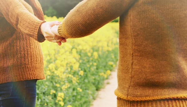 Coppia che si tiene per mano in amore all'aperto nella profondità della bella — Foto Stock