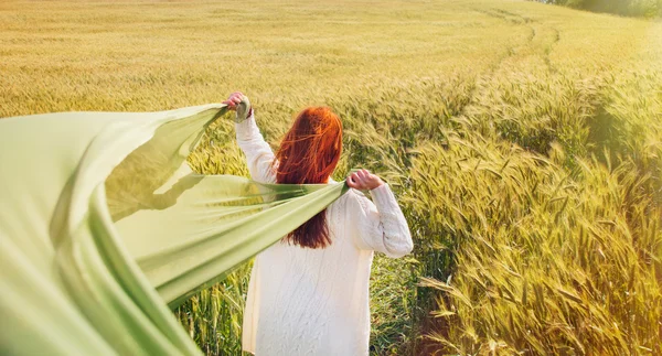 Mode rött hår kvinna stående tillbaka händerna med grönt tyg — Stockfoto