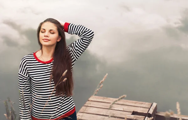 Cute attractive young woman enjoying harmony of nature on pier n — Stock Photo, Image