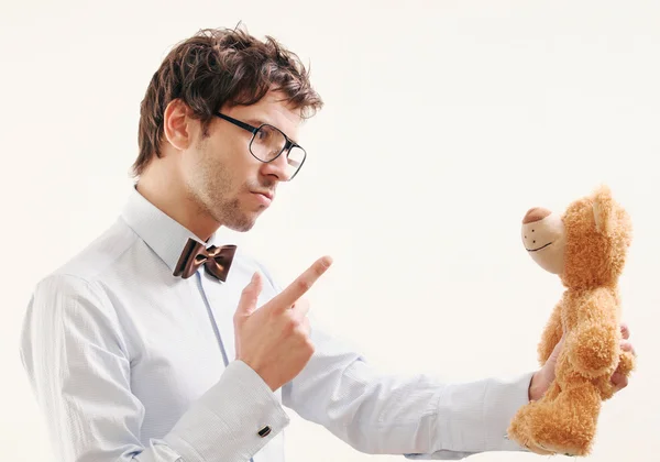 Portrait of serious handsome man scolding teddy bear — Stock Photo, Image