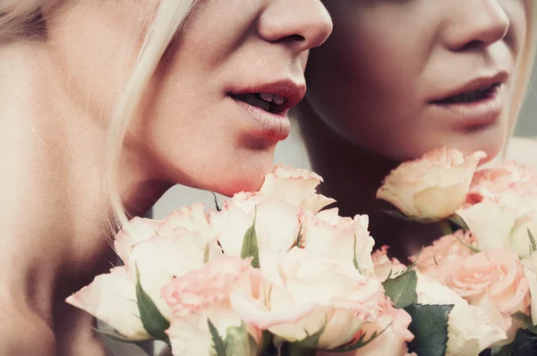 Fermer les lèvres sensuelles sourire femme en couleur pastel avec bouquet o — Photo