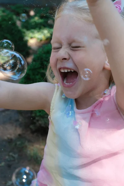 Pequeña Chica Divertida Feliz Con Pelo Rubio Captura Burbujas Jabón Imagen De Stock