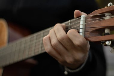 The guy plays the old guitar. Guitar in hands outdoor.