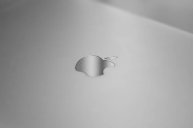 MacBook 'un üzerine Apple logosu. MacBook Air Pro masada. Apple logosunun makro görüntüsü. Laptopun alüminyum gümüş yüzeyi. MacBook 'un gri rengi.