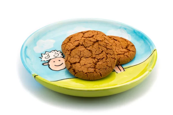 Smiling sheep underneath cookies on a colorful plate — Stock Photo, Image