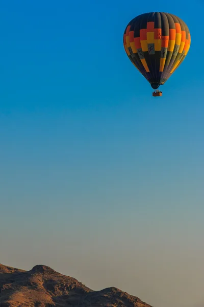 Hot air balloon floating above mountain — Stock Photo, Image