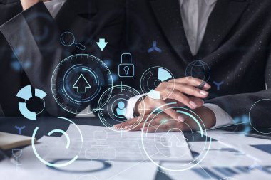 İki bilişim teknolojisi uzmanı iş hizmetlerini geliştirmek için yazılım geliştirmek üzere yeni bir yaklaşım geliştirme projesi üzerinde çalışıyor. Masanın üzerinde belgeyle birlikte teknolojik simgeler.