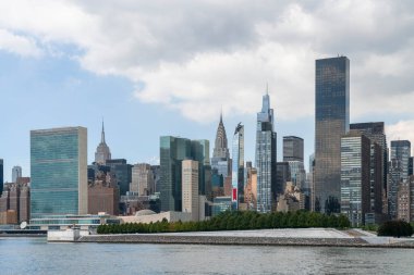 New York şehrinin ufuk çizgisi, Roosevelt adasından Doğu nehrine, Manhattan Midtown 'ın gökdelenlerine ve gündüz vakti Birleşmiş Milletler karargahına doğru, NYC, ABD. Parlak bir iş çevresi.