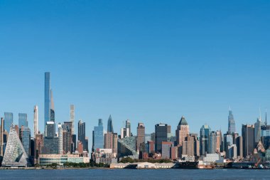 New York City gökdelenleri New Jersey 'den Hudson Nehri üzerinden gündüz vakti Hudson Yards bölgesinin gökdelenlerine bakıyor. Manhattan, Midtown, NYC, ABD. Parlak bir iş çevresi.