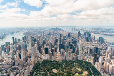 Manhattan 'ın ortasındaki Manhattan' ın aşağısına ve şehir merkezine doğru havadan panoramik şehir manzarası. Central Park, New York 'un en altında. Metropolis şehrinin helikopterinden kuş bakışı görüntü