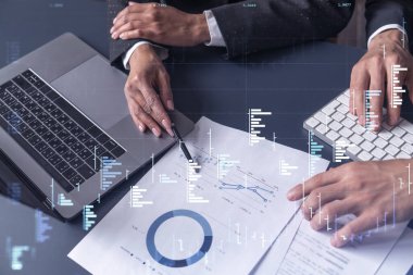 Borsa davranışlarını tahmin etmek için tarihi verileri araştıran iki tüccar ve kadın. İnternet ticareti konsepti. Belgelerin olduğu masanın üzerinde eski ve finansal hologram şeması