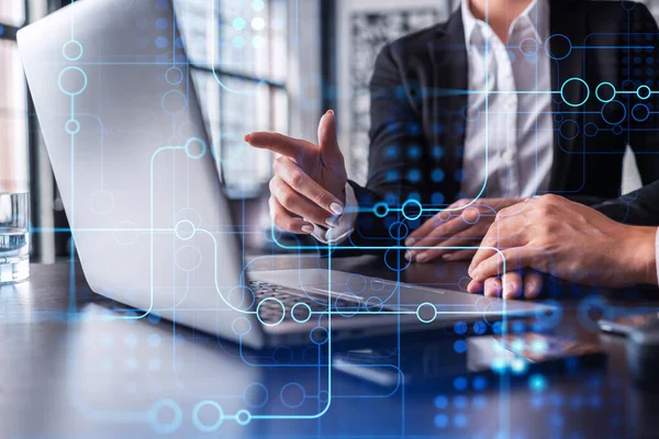 Two information technology specialist brainstorming on project to create a new approach to develop software to improve business service. Working with laptop. Tech hologram icons. — Stock Photo, Image