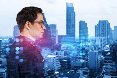 Uluslararası şirketteki yakışıklı HR müdürü yüksek nitelikli uzmanlar toplamak için verimli bir strateji düşünüyor. Bangkok arka planında sosyal medya ve pazarlama hologram simgeleri.