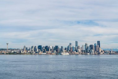Rıhtıma bakan Seattle silueti, harika tekerlek manzaralı ve ikonik gözlem kulesi Space Needle. Gündüz vakti Washington, ABD 'de finans merkezinin gökdelenleri. Parlak bir iş çevresi.