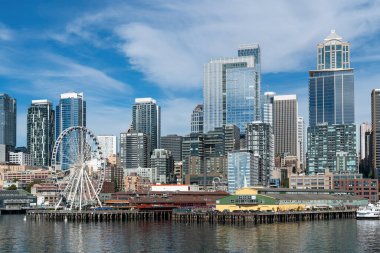 Rıhtıma bakan Seattle silueti harika tekerlek manzaralı. Gündüz vakti Washington, ABD 'de finans merkezinin gökdelenleri. Parlak bir iş çevresi.