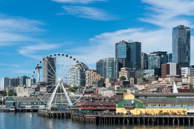 Rıhtıma bakan Seattle silueti harika tekerlek manzaralı. Gündüz vakti Washington, ABD 'de finans merkezinin gökdelenleri. Parlak bir iş çevresi.