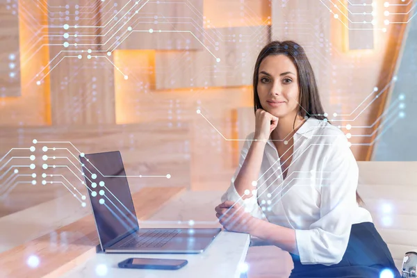 İş yerindeki beyaz tişörtlü çekici iş kadını iş hayatında yeni teknolojiler ima ederek gelişimi optimize etmek için dizüstü bilgisayarla çalışıyor. Ofis geçmişinde yüksek teknoloji hologramı